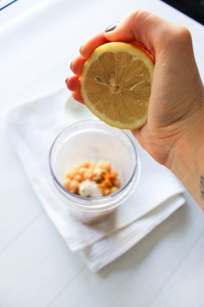Adding fresh lemon to hummus
