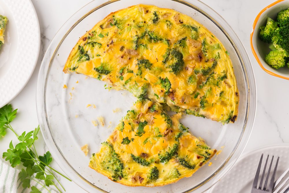 Cheesy Broccoli Frittata in a pie plate with one quarter missing